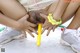 A woman in a white dress is playing with a yellow toy.