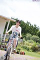 A woman riding a bike in a garden. 