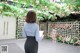 a woman standing in front of a floral wall