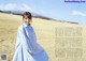 A woman in a blue dress standing in a field.